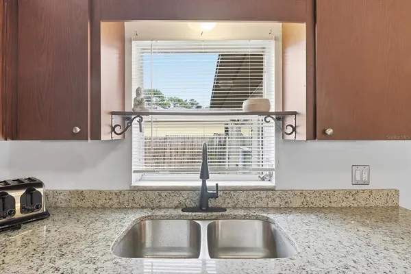 a kitchen with a sink cabinets and window