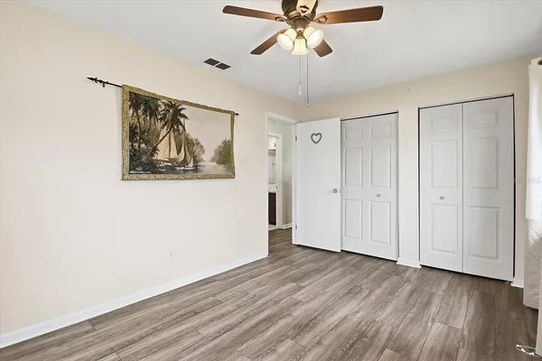 a view of a hallway with wooden floor and closet area