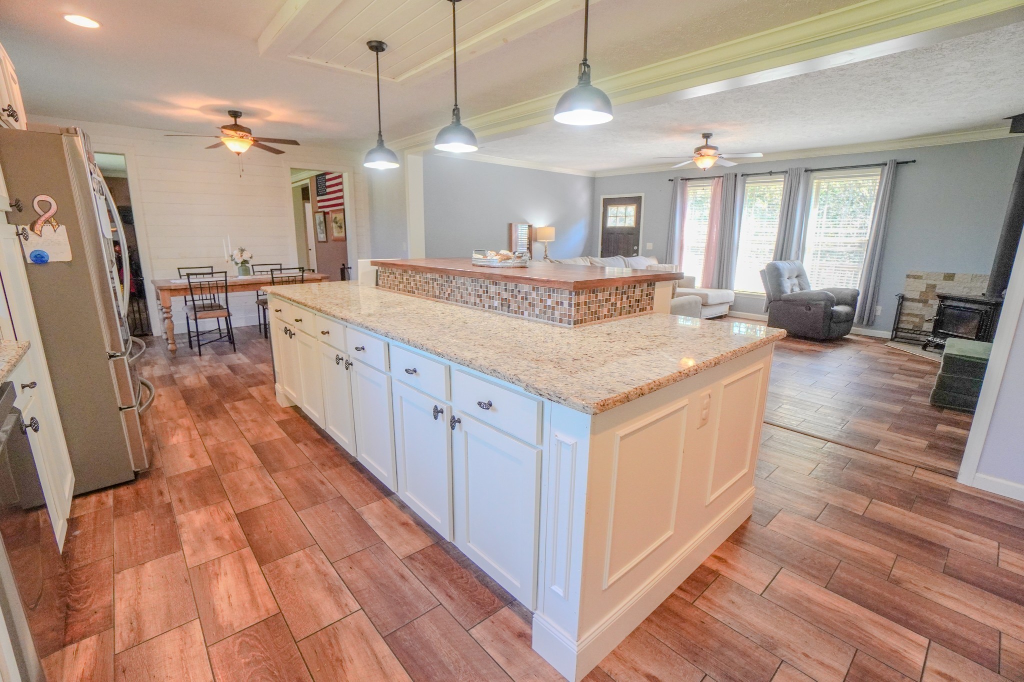 137 Hawkins Road Westmoreland, TN 37186 - Photo 32 of 71 a large white kitchen with a large island oven a stove a sink and a wooden floor