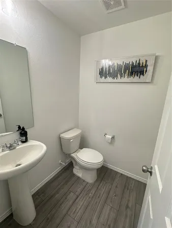 a bathroom with a toilet a sink and mirror