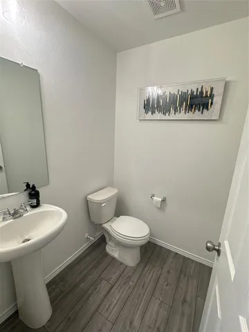 a bathroom with a toilet a sink and mirror
