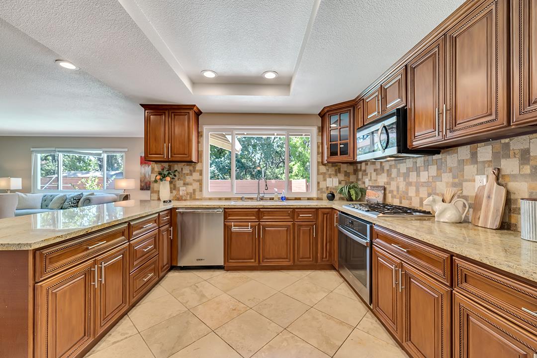 3151 Stone Valley Road Danville, CA 94526 - Photo 19 of 41 a kitchen with stainless steel appliances granite countertop wooden cabinets a sink and dishwasher a stove top oven with wooden floor