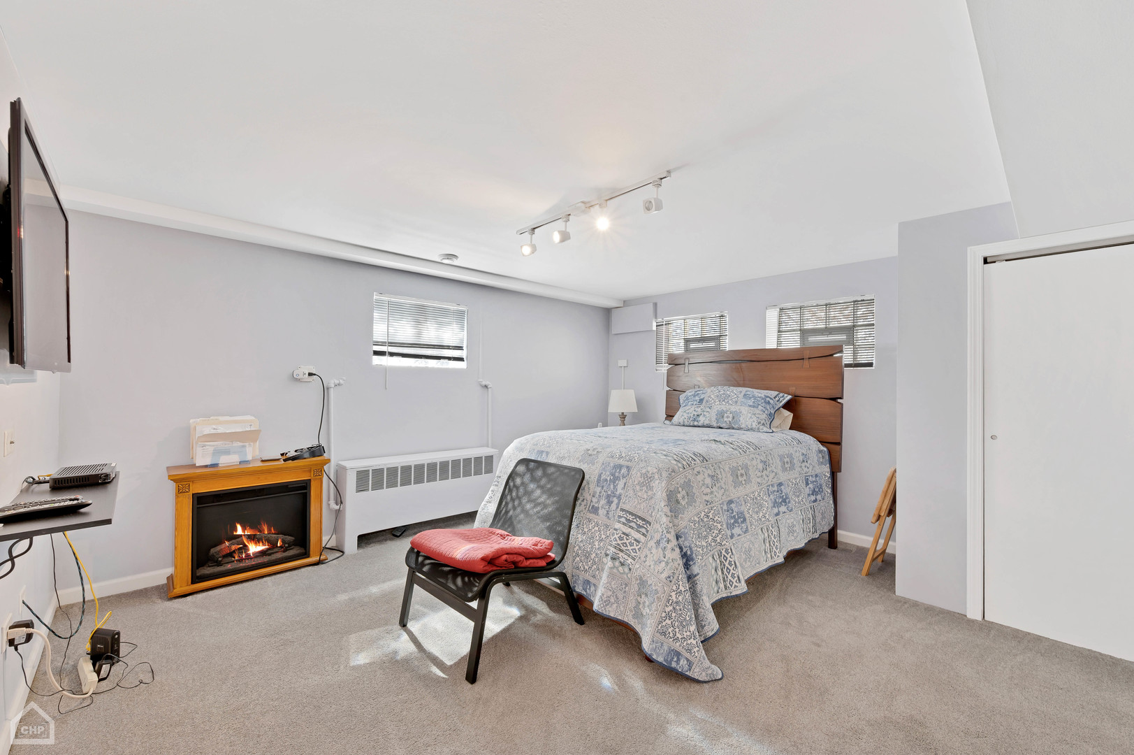 8912 Forestview Road Evanston, IL 60203 - Photo 13 of 31 a bedroom with a bed a fireplace and a stool