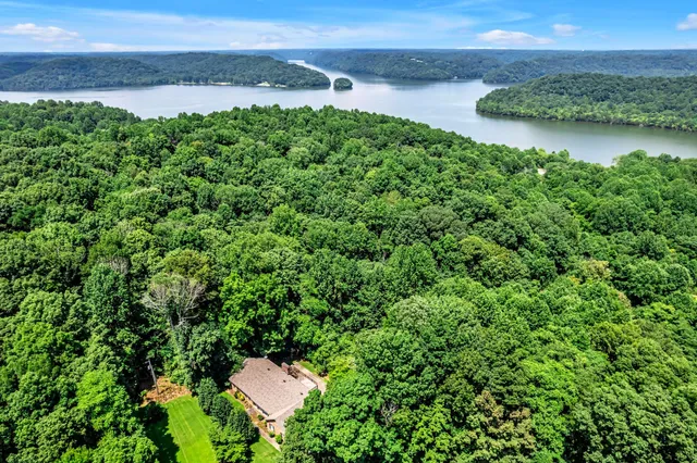 an aerial view of a house with a yard and lake view