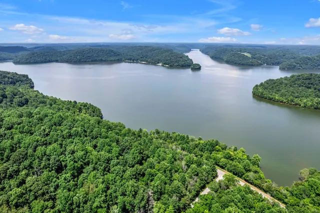 an aerial view of a houses with a yard and lake view