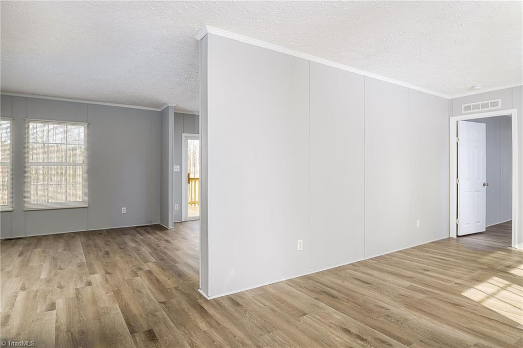 1591 Carson Road Pilot Mountain, NC 27041 - Photo 11 of 50 Dividing wall between back den with fireplace and living room on front of the home with doorway leading to the office and then primary bedroom