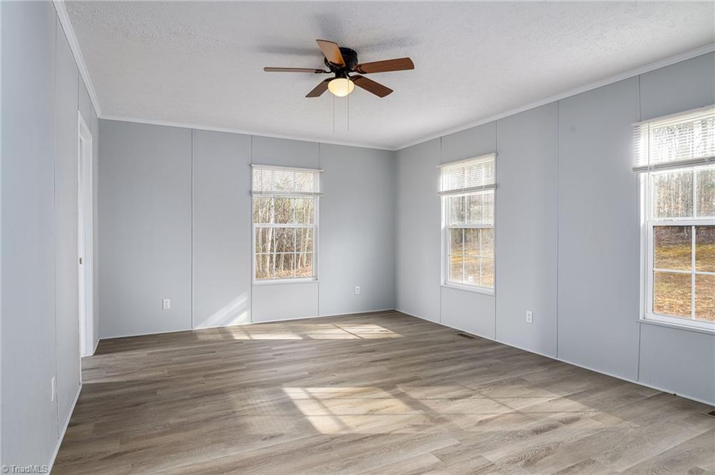 1591 Carson Road Pilot Mountain, NC 27041 - Photo 15 of 50 Very large primary bedroom with lots of windows, new blinds, new paint on walls & ceiling, ceiling fan with light kit and huge walk in closet