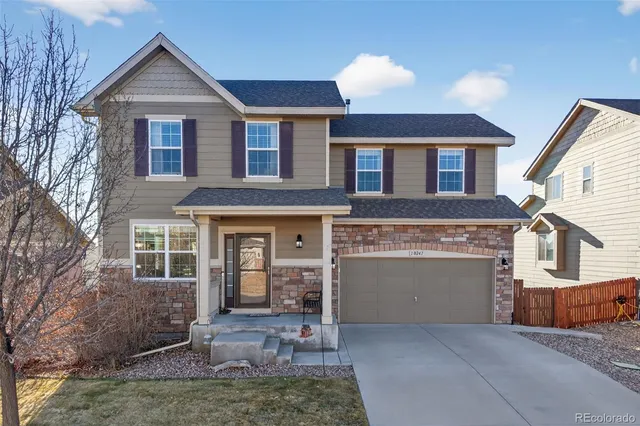 a front view of a house with yard and parking