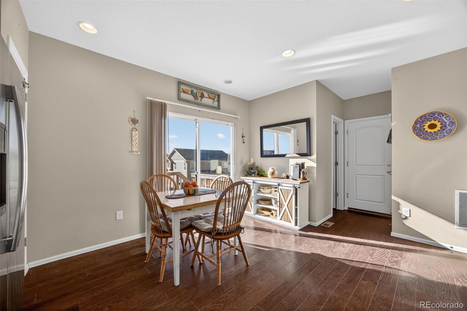 10247 Olathe Way Commerce City, CO 80022 - Photo 12 of 37 a view of a dining room with furniture and a wooden floor