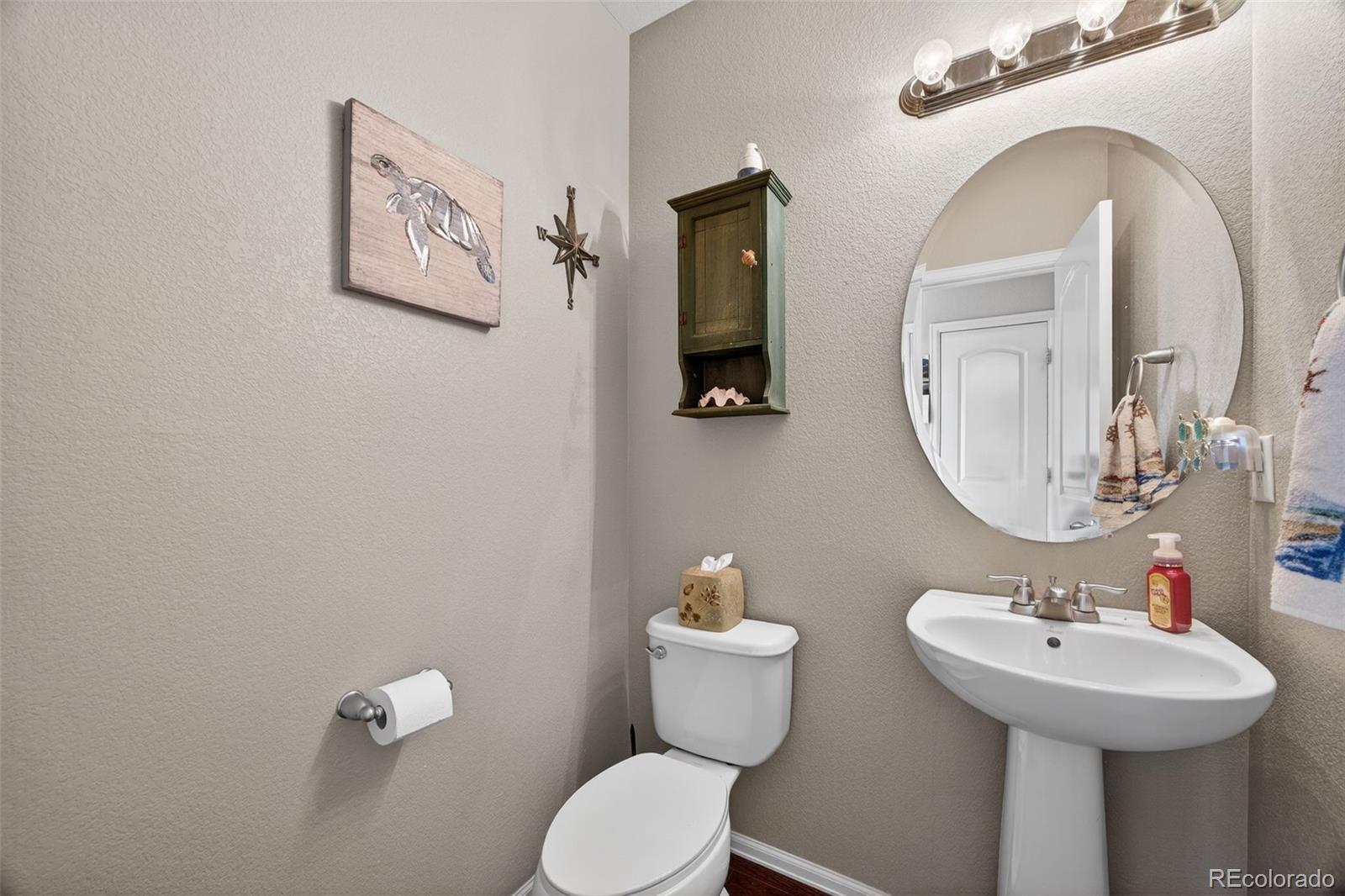 10247 Olathe Way Commerce City, CO 80022 - Photo 15 of 37 a bathroom with a toilet sink and mirror