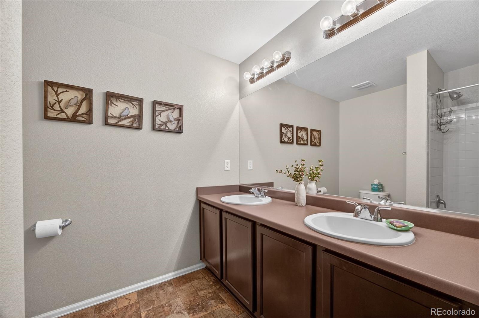10247 Olathe Way Commerce City, CO 80022 - Photo 18 of 37 a bathroom with a sink and a mirror