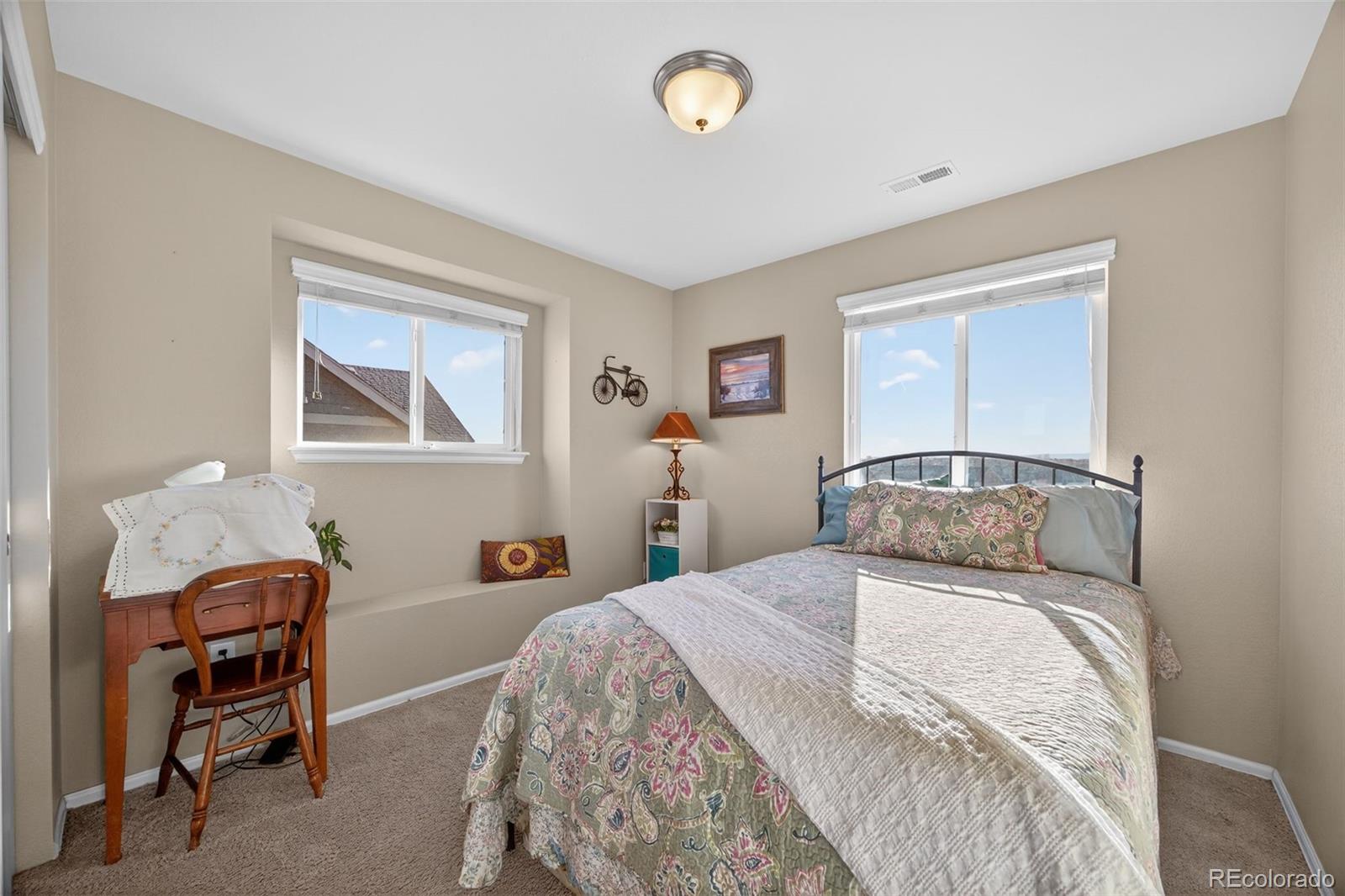 10247 Olathe Way Commerce City, CO 80022 - Photo 19 of 37 a bedroom with a bed and a table