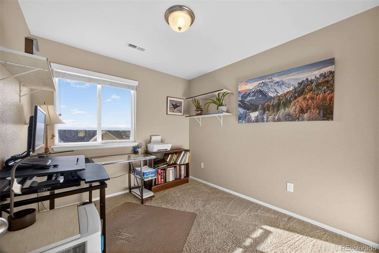 10247 Olathe Way Commerce City, CO 80022 - Photo 20 of 37 a view of a workspace with furniture and a window