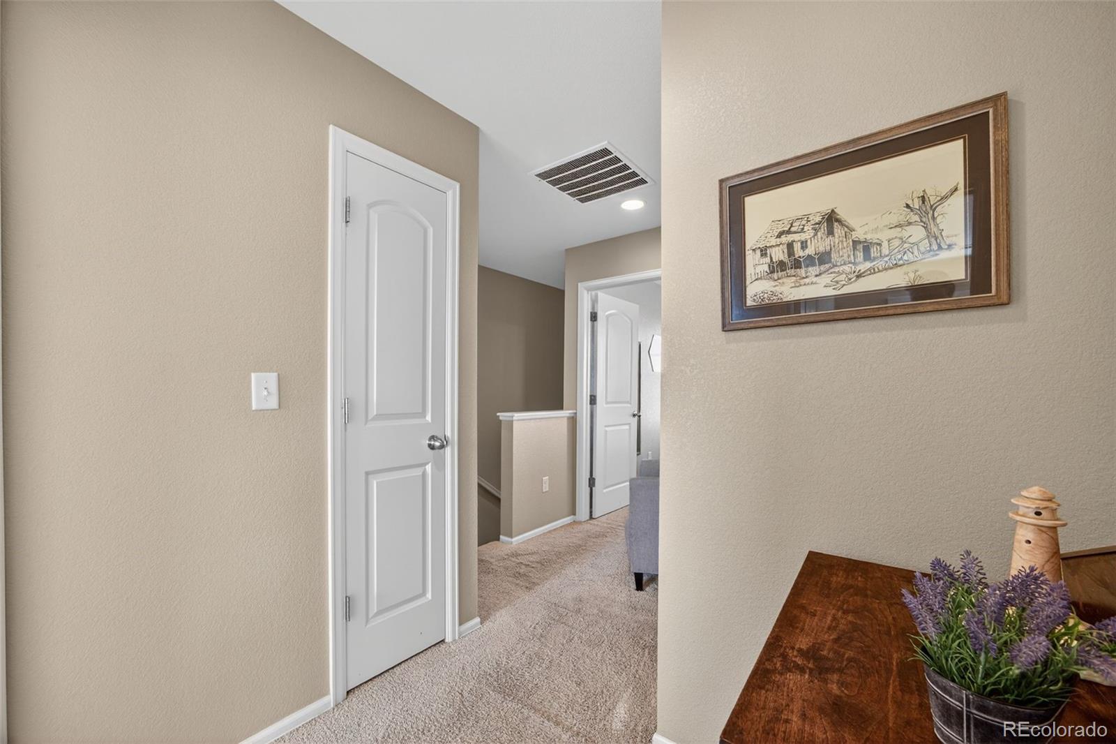 10247 Olathe Way Commerce City, CO 80022 - Photo 22 of 37 a view of a hallway with front door and wooden floor