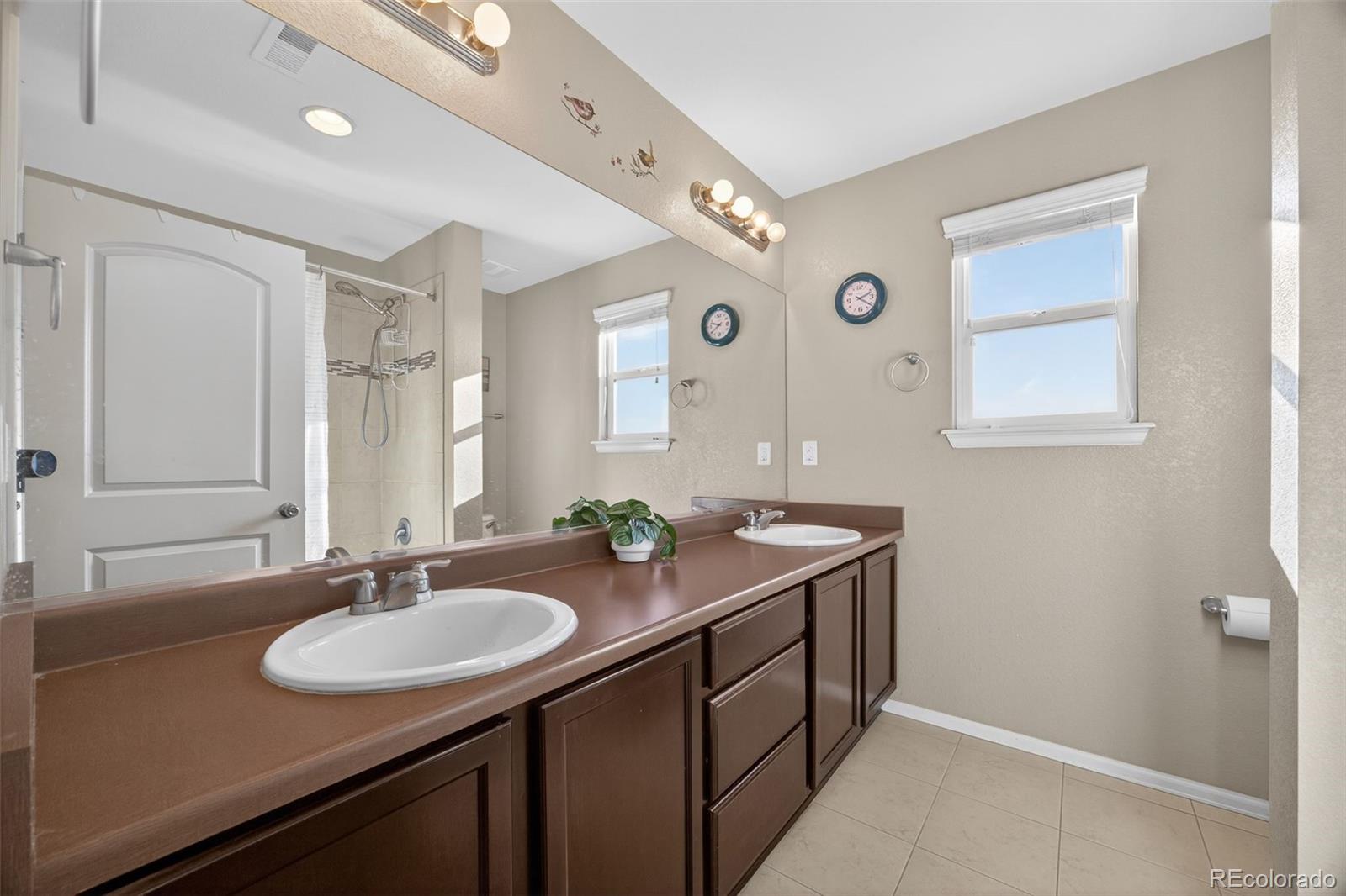 10247 Olathe Way Commerce City, CO 80022 - Photo 27 of 37 a bathroom with a sink double vanity and a mirror