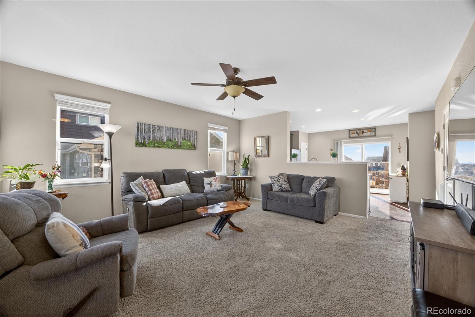 10247 Olathe Way Commerce City, CO 80022 - Photo 6 of 37 a living room with furniture and a ceiling fan