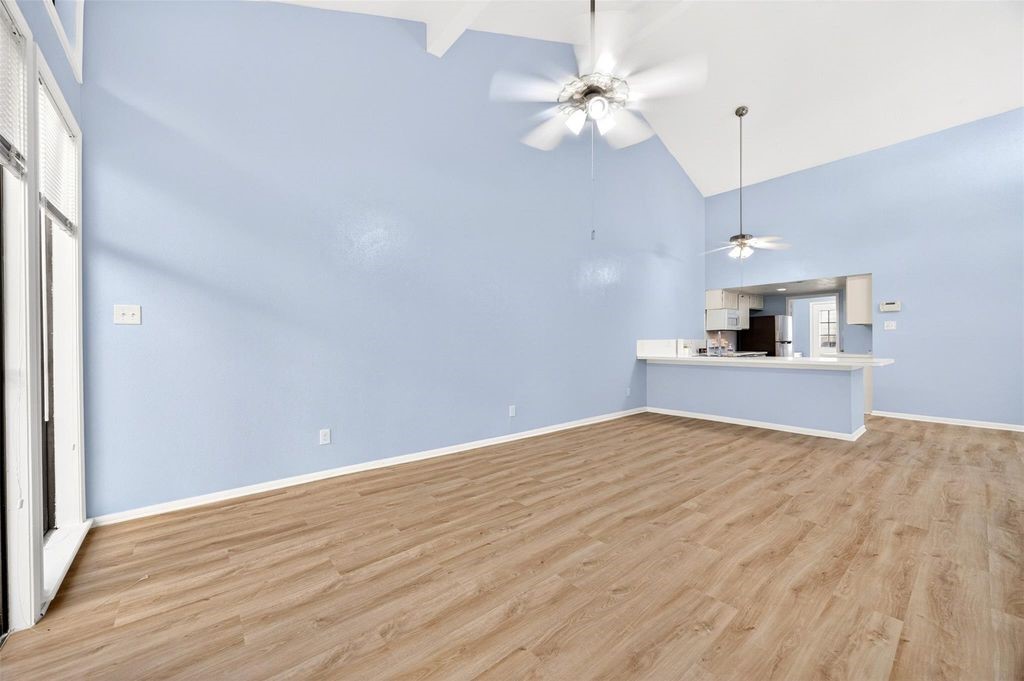 17 April Point Drive North Conroe, TX 77356 - Photo 16 of 42 a view of a kitchen with an empty space and a ceiling fan