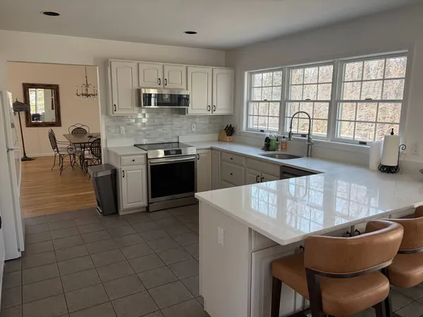 a kitchen with stainless steel appliances granite countertop a stove a sink a microwave and a refrigerator