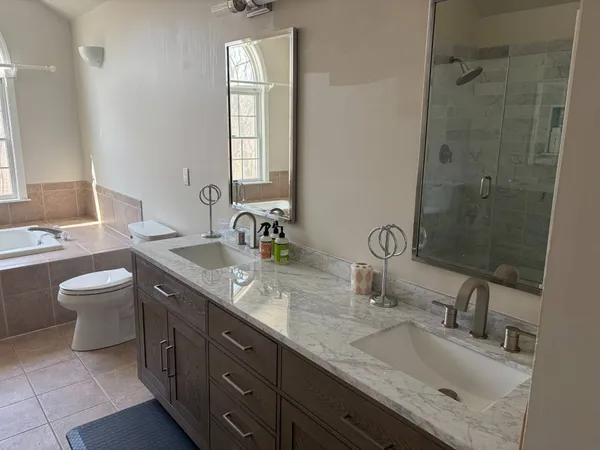 a bathroom with a granite countertop sink a toilet and a mirror