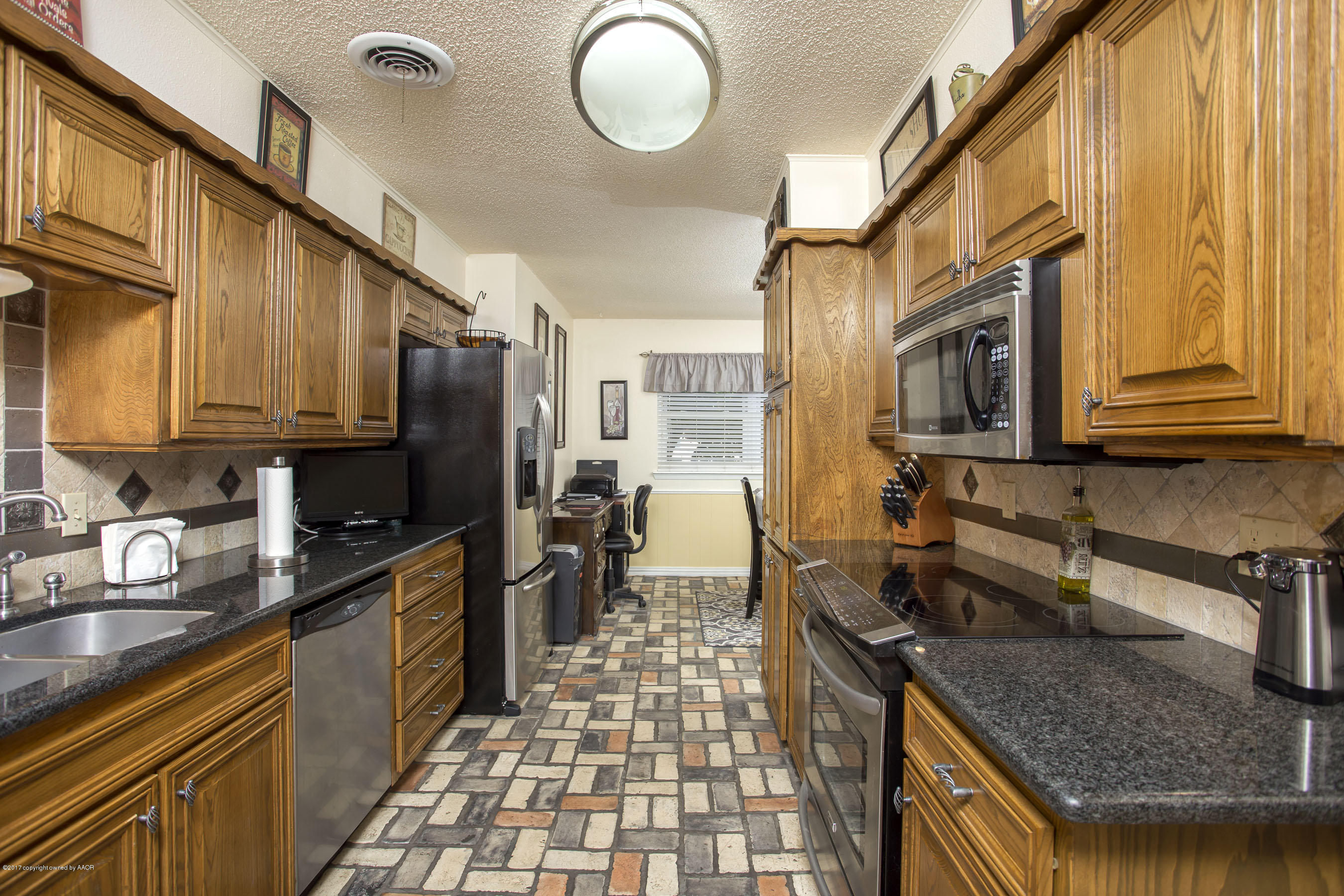 7202 Gainsborough Road Amarillo, TX 79106 - Photo 7 of 27 a kitchen with stainless steel appliances granite countertop a sink stove and refrigerator