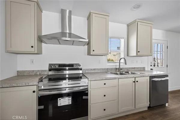 a kitchen with granite countertop a sink stove and cabinets