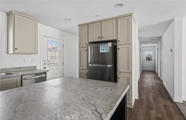 a kitchen with granite countertop a refrigerator and a sink