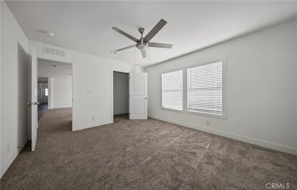 an empty room with closet and windows