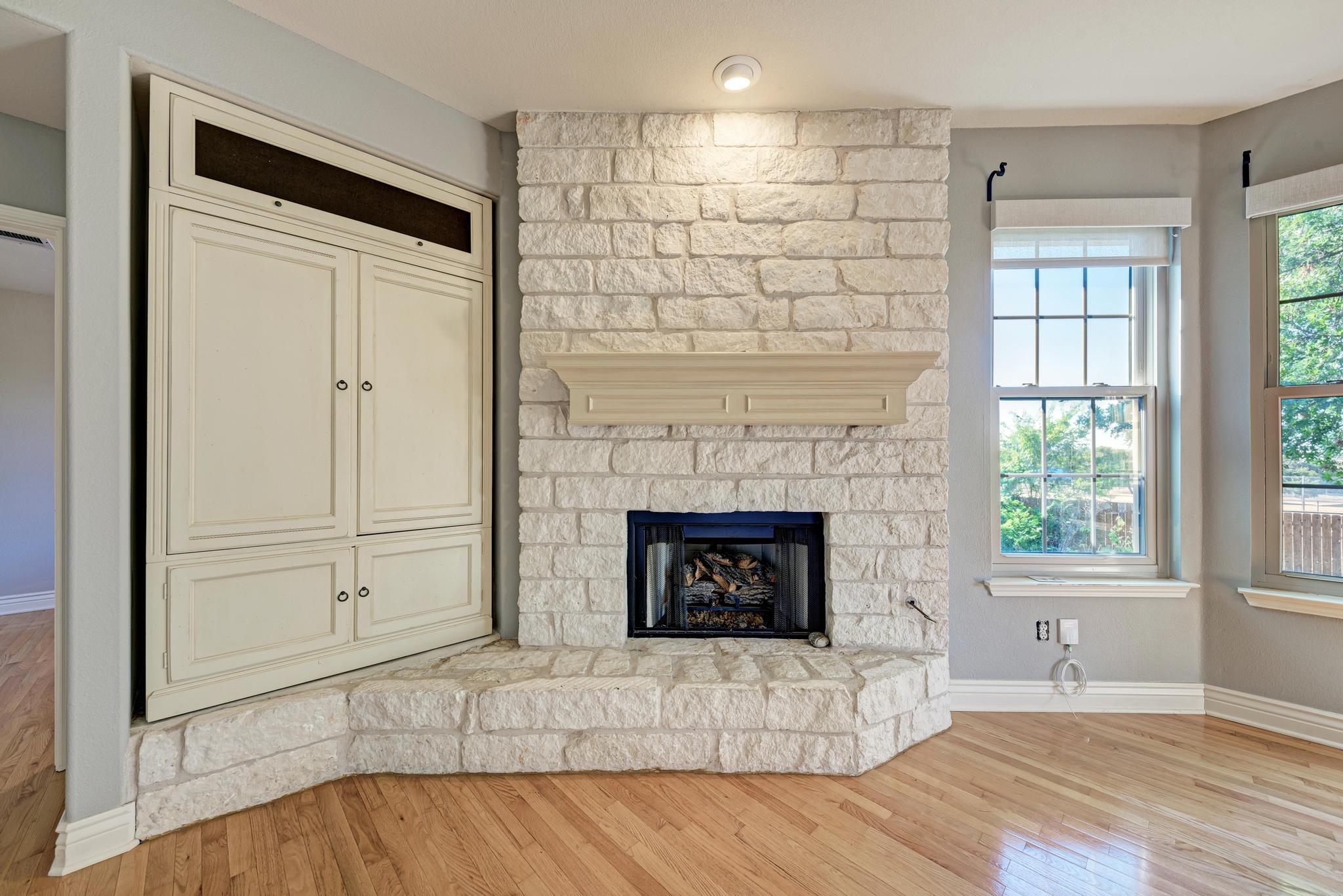 906 Antelope Ridge Cedar Park, TX 78613 - Photo 13 of 40 Warm hardwood floors complement a textured stone fireplace and custom built-in cabinetry.