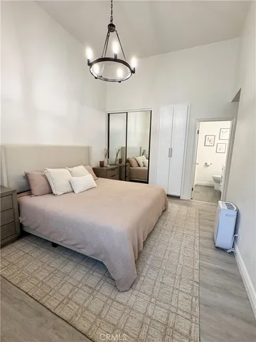 a bedroom with a large bed and a chandelier