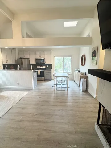 a view of living room kitchen with stove and cabinets