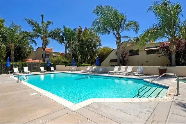 a view of swimming pool with outdoor seating and palm trees