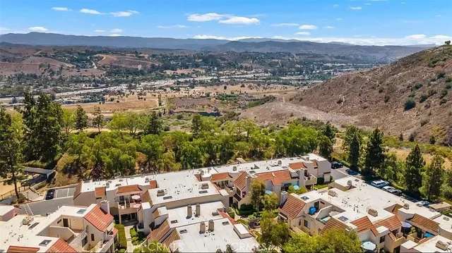 an aerial view of a house with a mountain