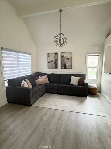 a living room with furniture wooden floor and window