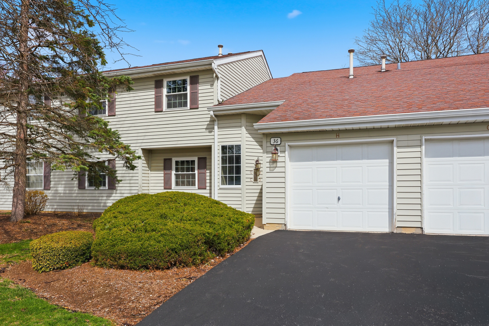 36 Gant Circle, Unit H Streamwood, IL 60107 - Photo 1 of 22 a front view of a house with a garden and plants