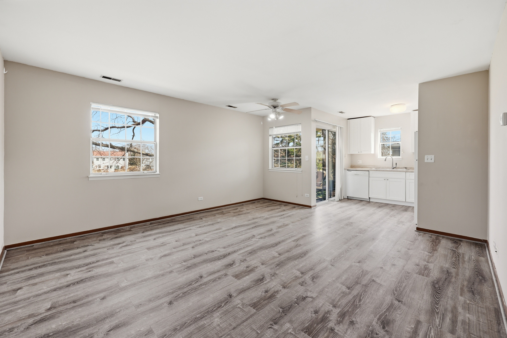 36 Gant Circle, Unit H Streamwood, IL 60107 - Photo 5 of 22 an empty room with wooden floor cabinet and windows