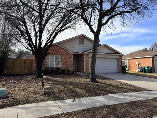 a front view of a house with garden and trees