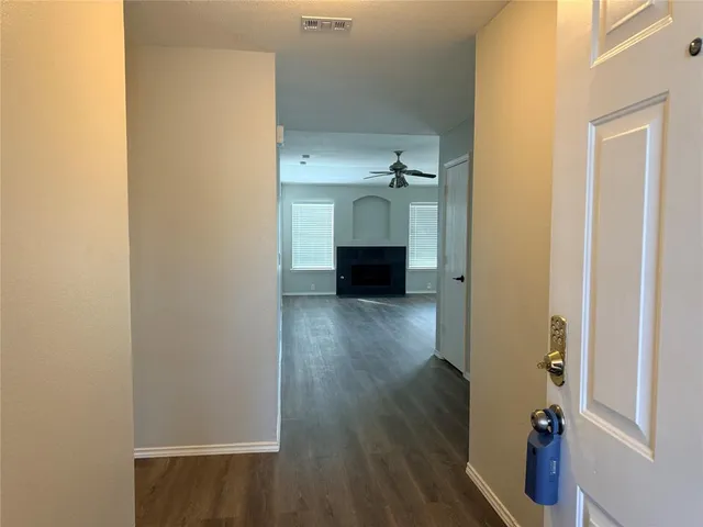 a view of a hallway with wooden floor and closet