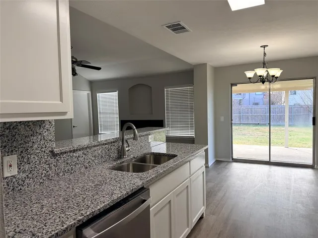 a kitchen with a sink and chandelier