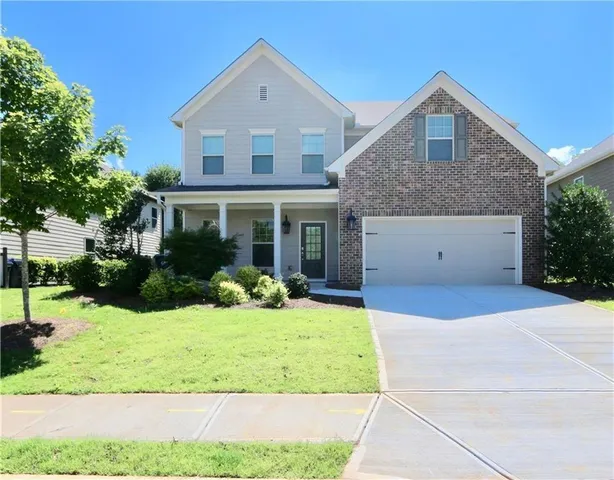 a front view of a house with a yard and garage