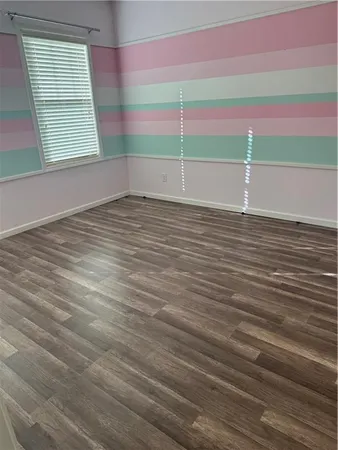 a view of a room with wooden floor and windows