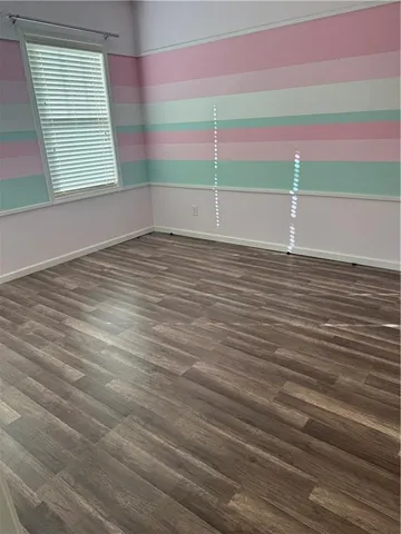 a view of a room with wooden floor and windows