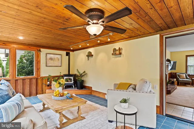 a living room with furniture a ceiling fan and a large window