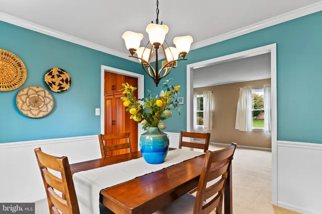 a dining room with a wooden table and chairs