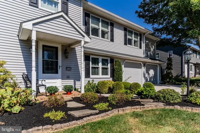 a front view of a house with a yard and potted plants