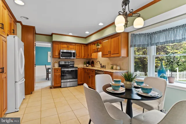 a kitchen with sink refrigerator dining table and chairs