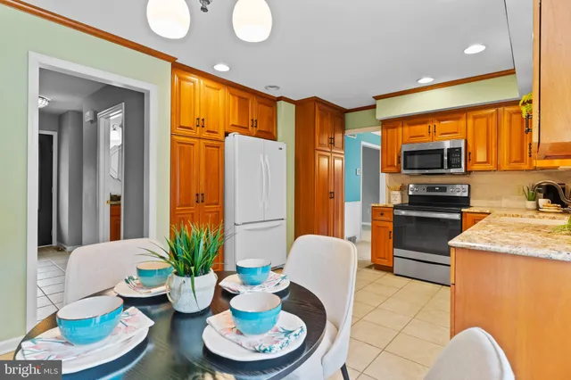 a kitchen with stainless steel appliances a dining table a stove a dining table and chairs
