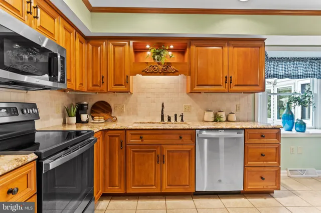 a kitchen with stainless steel appliances granite countertop a stove a sink and a microwave