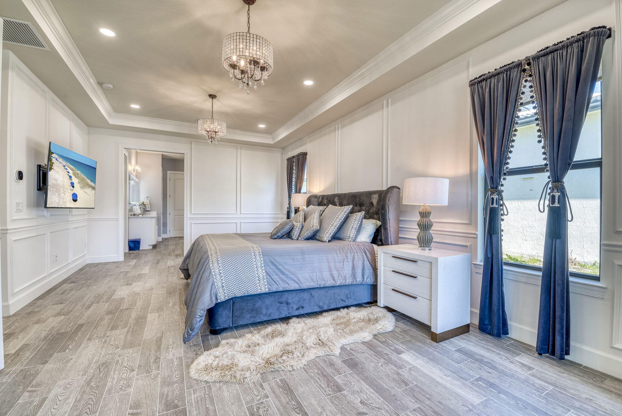 114 Cinder Dunes Point Jupiter, FL 33478 - Photo 26 of 62 a spacious bedroom with a large bed and a chandelier