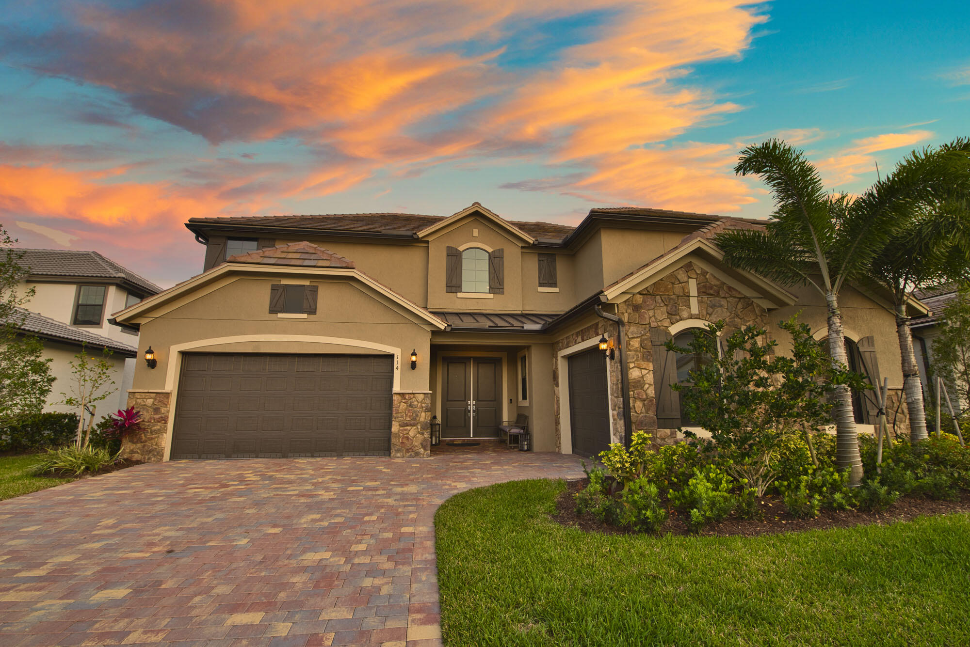 114 Cinder Dunes Point Jupiter, FL 33478 - Photo 56 of 62 a front view of a house with a garden and plants