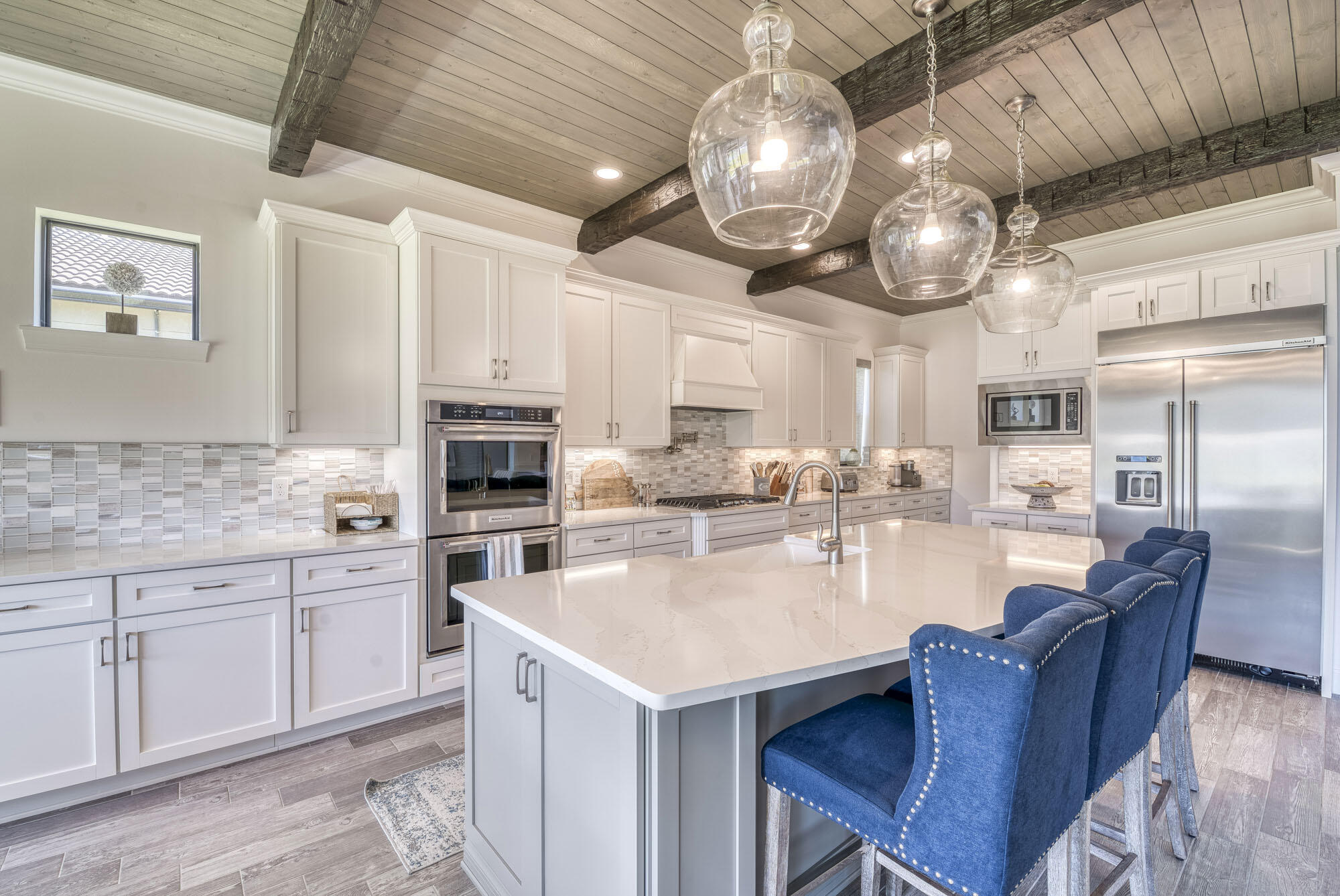 114 Cinder Dunes Point Jupiter, FL 33478 - Photo 7 of 62 a kitchen with stainless steel appliances granite countertop a kitchen island a stove a sink a dining table and chairs with wooden floor